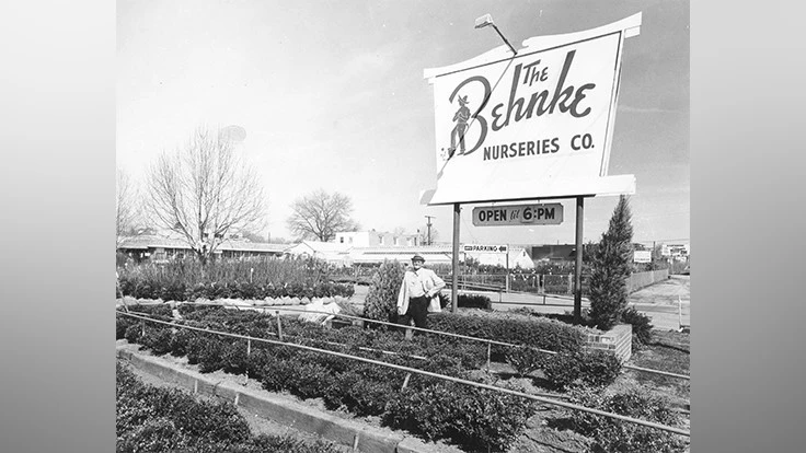 Albert Behnke poses in front of The Behnke Nurseries Co. sign sometime in the 1960's